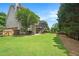 Large backyard with green grass, mature trees, and a wooded perimeter for privacy at 4653 Glory Maple Trce, Powder Springs, GA 30127