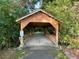 Rustic wooden covered bridge surrounded by lush greenery providing an idyllic neighborhood crossing at 4653 Glory Maple Trce, Powder Springs, GA 30127