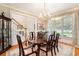 Inviting dining room with a large window, chandelier, hardwood floors, and a traditional dining set at 4653 Glory Maple Trce, Powder Springs, GA 30127