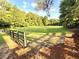 Expansive grassy field surrounded by lush trees and a rustic wooden fence provides a serene and picturesque view at 4653 Glory Maple Trce, Powder Springs, GA 30127