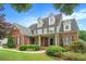 Charming two-story brick home featuring a welcoming front porch, lush landscaping, and a well-maintained lawn at 4653 Glory Maple Trce, Powder Springs, GA 30127