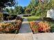 Beautifully landscaped walkway lined with colorful flowers leads to a pool and community area, perfect for relaxation at 4653 Glory Maple Trce, Powder Springs, GA 30127