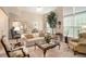 Bright living room with neutral tones, large windows, and plush seating creates a comfortable space at 4653 Glory Maple Trce, Powder Springs, GA 30127