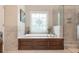 Bright main bath boasts soaking tub with wood paneling and glass-enclosed shower at 4653 Glory Maple Trce, Powder Springs, GA 30127