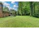 Vast backyard with lush lawn, mature trees, and patio seating area offering ample space for recreation at 595 Glenforest Rd, Sandy Springs, GA 30328