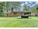 Expansive backyard featuring a brick home, outdoor seating area, screened porch and lush green lawn at 595 Glenforest Rd, Sandy Springs, GA 30328