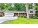 Charming home featuring a brick facade, a two-car garage, and a well-maintained landscaped yard at 595 Glenforest Rd, Sandy Springs, GA 30328