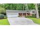 Home exterior with a two-car garage, manicured lawn, and brick accents create an inviting curb appeal at 595 Glenforest Rd, Sandy Springs, GA 30328