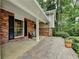 Inviting covered front porch area featuring brick accents, seating and great natural light at 595 Glenforest Rd, Sandy Springs, GA 30328