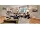 Spacious living room featuring hardwood floors, a large window, comfortable seating, and stylish decor at 595 Glenforest Rd, Sandy Springs, GA 30328