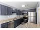 Updated kitchen boasts gray cabinets, granite countertops, and modern stainless steel appliances at 6726 Gallant Se Ct # 30, Mableton, GA 30126