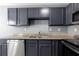 Renovated kitchen features gray cabinets, granite countertops, and stainless steel appliances at 6726 Gallant Se Ct # 30, Mableton, GA 30126