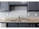 Kitchen sink with granite countertops and sleek gray cabinets at 6726 Gallant Se Ct # 30, Mableton, GA 30126