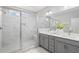Bathroom featuring a glass-enclosed shower with marble tile and a double sink vanity, offering luxury at 908 Catamaran Ct, Alpharetta, GA 30005