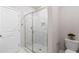 Bathroom with glass shower doors and modern tile surround and a decorative accent flower on the toilet at 908 Catamaran Ct, Alpharetta, GA 30005