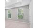Bright bedroom with two large windows, providing ample natural light and a view of the outdoors at 908 Catamaran Ct, Alpharetta, GA 30005