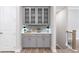 Gray butlers pantry with glass door cabinets and hardwood floors at 908 Catamaran Ct, Alpharetta, GA 30005