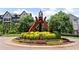 Community entrance with landscaping and modern sculpture, with homes in the background at 908 Catamaran Ct, Alpharetta, GA 30005
