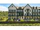 View of luxury townhomes with black framed windows, painted brick and beautifully manicured landscaping at 908 Catamaran Ct, Alpharetta, GA 30005