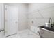 Laundry room with marble tile floors, stainless steel sink and white wire rack above at 908 Catamaran Ct, Alpharetta, GA 30005
