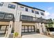 View of the back of the home and attached two car garages with black and white garage doors at 908 Catamaran Ct, Alpharetta, GA 30005