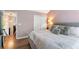 Serene bedroom features plush bedding, hardwood floors, and soft lighting, promoting relaxation at 949 Pike Forest Dr, Lawrenceville, GA 30045