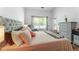 Comfortable bedroom with a tufted headboard, soft lighting, and serene backyard views at 949 Pike Forest Dr, Lawrenceville, GA 30045