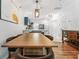 Open concept dining area featuring a large wooden table, modern light fixtures, and hardwood floors at 949 Pike Forest Dr, Lawrenceville, GA 30045