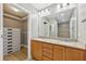 Bright bathroom with double vanity, granite countertop, a large mirror, and access to a walk-in closet at 171 Auburn Ne Ave # 210, Atlanta, GA 30303