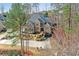 Breathtaking aerial view of a beautiful home with lush landscaping, a long driveway, and stunning curb appeal at 11180 West Rd, Roswell, GA 30075