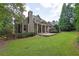 Backyard featuring a stone patio, lush lawn, and mature trees at 11180 West Rd, Roswell, GA 30075