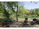 Scenic backyard featuring a lake view, sitting area with chairs, and a canoe, creating a tranquil outdoor space at 11180 West Rd, Roswell, GA 30075
