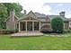 Rear exterior showcasing the home's covered porch and stone patio overlooking the backyard at 11180 West Rd, Roswell, GA 30075