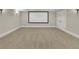 Finished basement space features a large media screen, neutral carpet and light paint at 11180 West Rd, Roswell, GA 30075