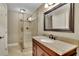 Elegant bathroom features a walk-in shower with glass door and granite vanity with a large, framed mirror at 11180 West Rd, Roswell, GA 30075