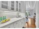 Stylish butler's pantry with white cabinets, marble countertops, and glass-front cabinets, perfect for entertaining at 11180 West Rd, Roswell, GA 30075