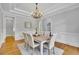 Bright dining room with a chandelier, white wainscoting, and a large window for natural light at 11180 West Rd, Roswell, GA 30075