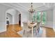 Elegant dining room with white wainscoting, a chandelier, and a large arched window showcasing the lush landscape at 11180 West Rd, Roswell, GA 30075