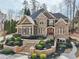 Stunning stone and brick home boasting elegant landscaping, a grand entrance, and a well-manicured front yard at 11180 West Rd, Roswell, GA 30075