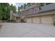 Beautiful two-story home featuring a three-car garage, stone accents, and a spacious driveway at 11180 West Rd, Roswell, GA 30075