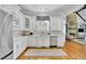 A modern white kitchen features stainless steel appliances, custom cabinets, and hardwood floors extending to the adjacent living area at 11180 West Rd, Roswell, GA 30075