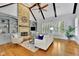 Cozy living room features a stone fireplace, vaulted ceilings, and hardwood floors at 11180 West Rd, Roswell, GA 30075