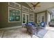 Covered patio with stone floors, seating, ceiling fan and view of wooded backyard at 11180 West Rd, Roswell, GA 30075