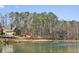 Scenic view of a home by a pond with a fountain, nestled among tall trees and manicured landscaping at 11180 West Rd, Roswell, GA 30075