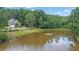 Scenic view of a well-maintained property with a pond featuring a fountain, surrounded by lush greenery at 11180 West Rd, Roswell, GA 30075