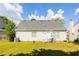 Manicured backyard with patio furniture, a well-maintained lawn, and white vinyl siding at 2545 Lake Royale Dr, Riverdale, GA 30296