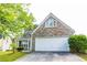 Charming home featuring stone accents, a white garage door, and well-manicured landscaping at 2545 Lake Royale Dr, Riverdale, GA 30296