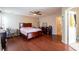 Large main bedroom with wood floors, ceiling fan, adjacent bathroom, and ample space for a desk at 2545 Lake Royale Dr, Riverdale, GA 30296