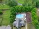 Aerial view of a beautiful backyard pool with patio, lounge chairs, privacy landscaping, and lush green lawn at 1889 Raegan Way, Lawrenceville, GA 30043