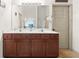 Bathroom with double vanity, large mirror, and neutral color scheme at 1889 Raegan Way, Lawrenceville, GA 30043